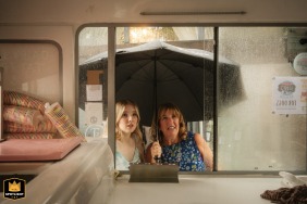 A unique perspective capturing guests queuing in the rain outside a traditional ice cream van at a wedding in Willerby Hill, Hull, UK.